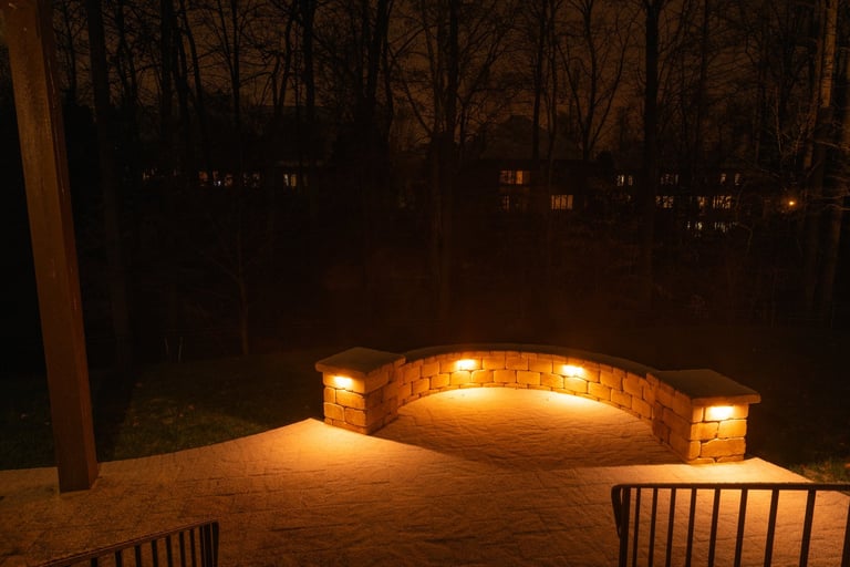 Backyard patio with stone wall at night