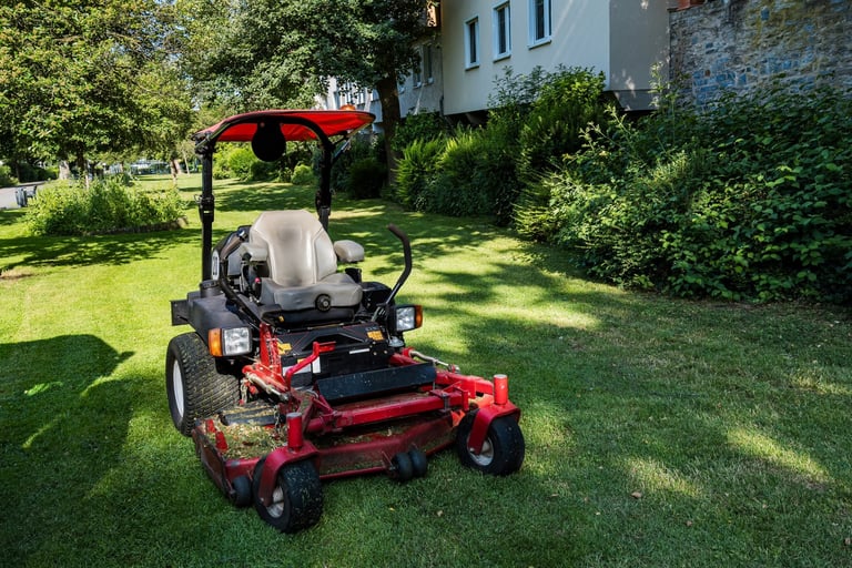Riding mower on freshly cut grass in residential area