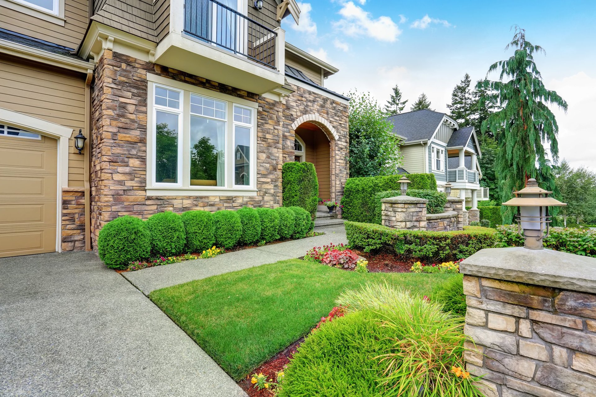 Beautiful landscaped property with stone trim and perfectly trimmed shrubs